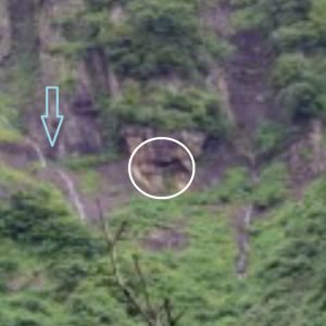 Close up of the distant cave and nearby waterfall